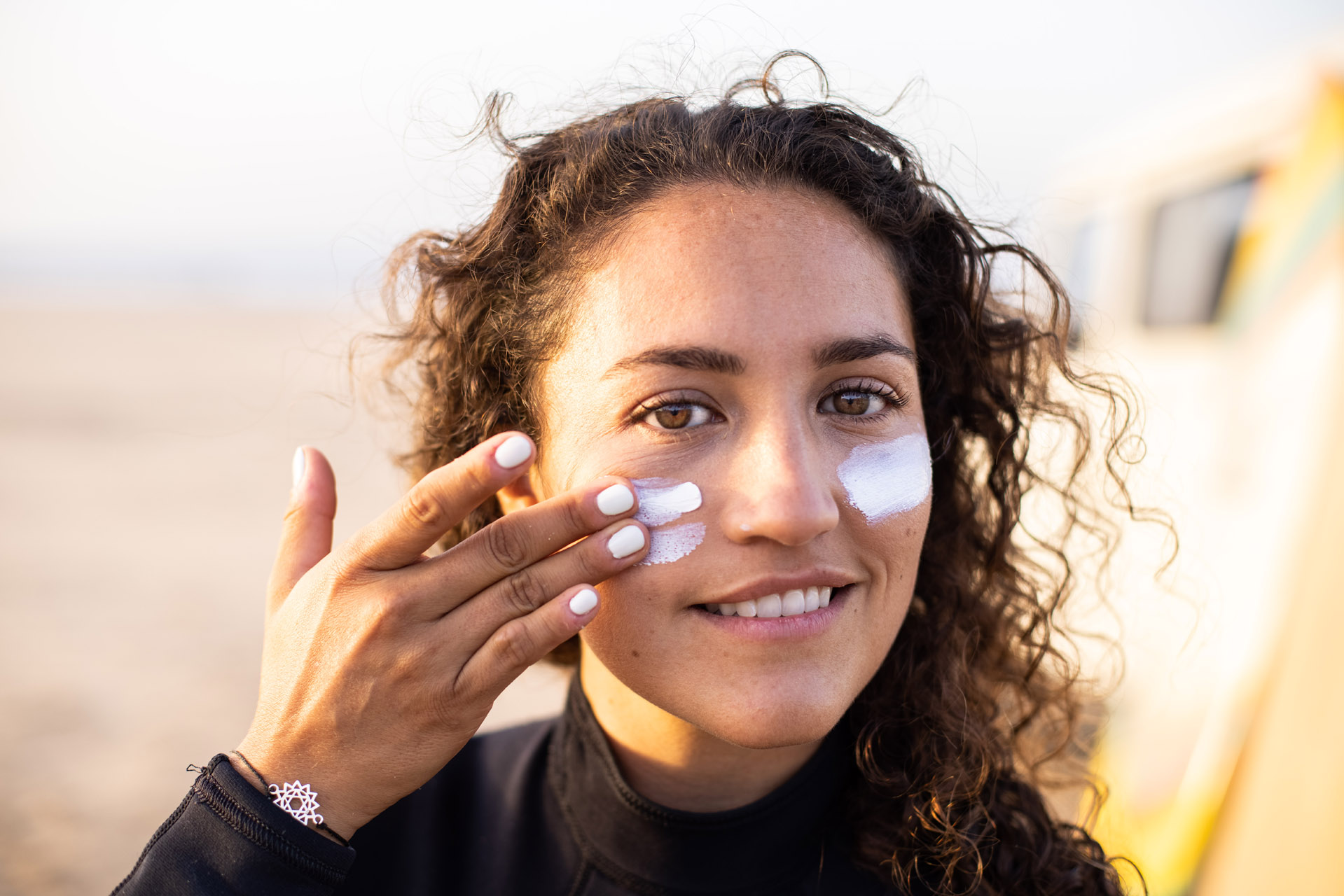 Frau trägt Sonnencreme im Freien.