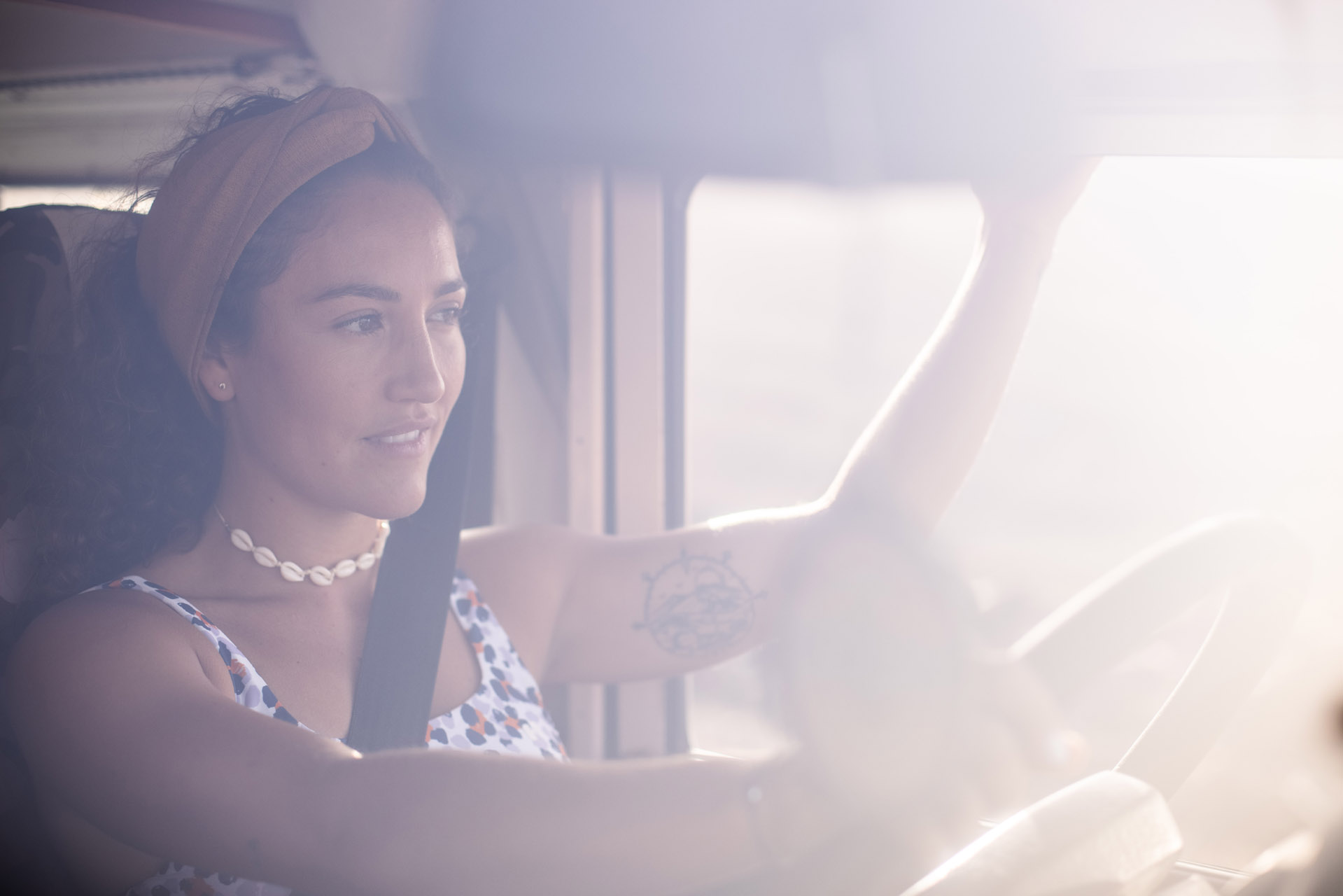 Frau fährt ein Fahrzeug mit lächelndem Gesicht.