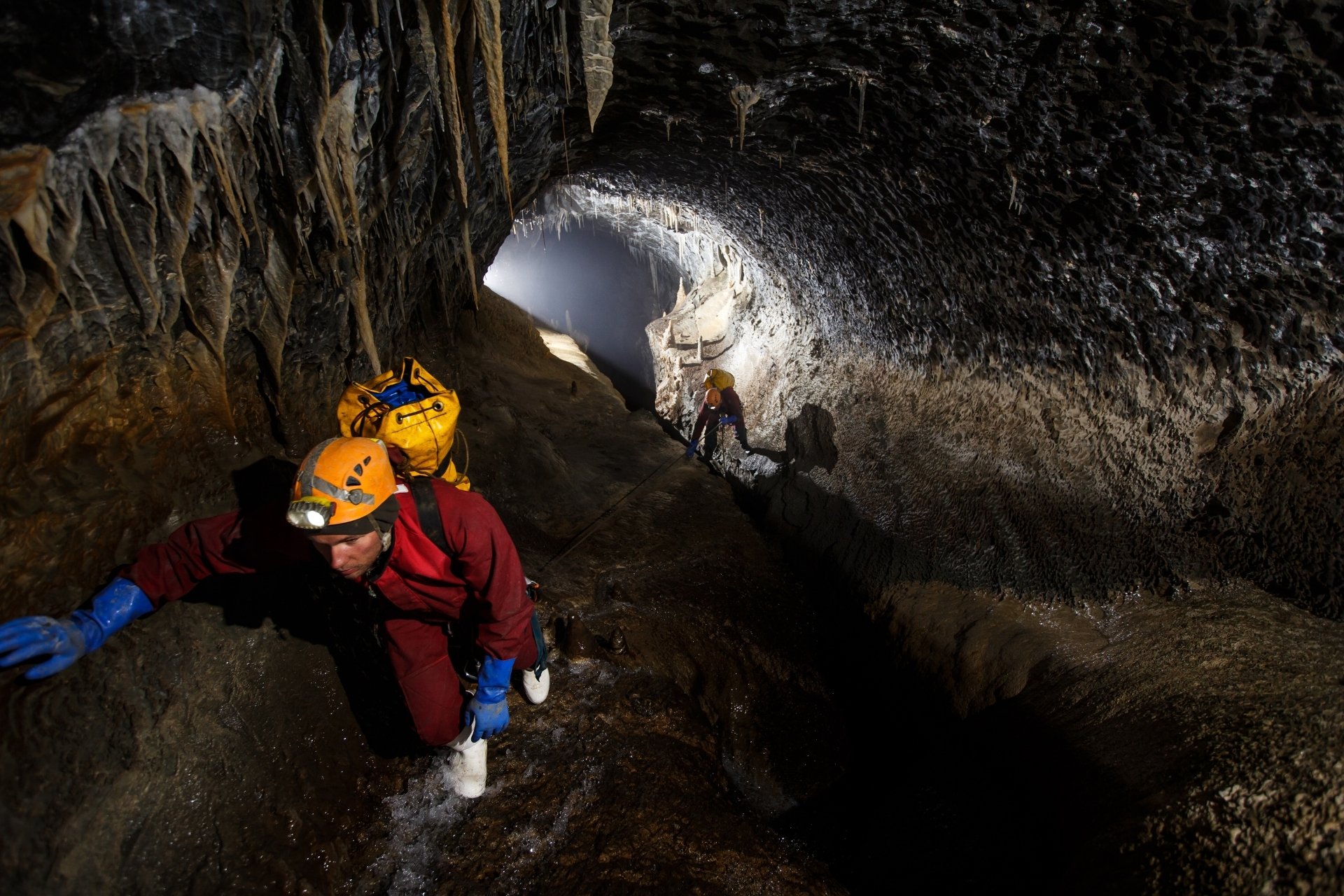 Kletterer in einer Höhle mit glitschigem Untergrund.