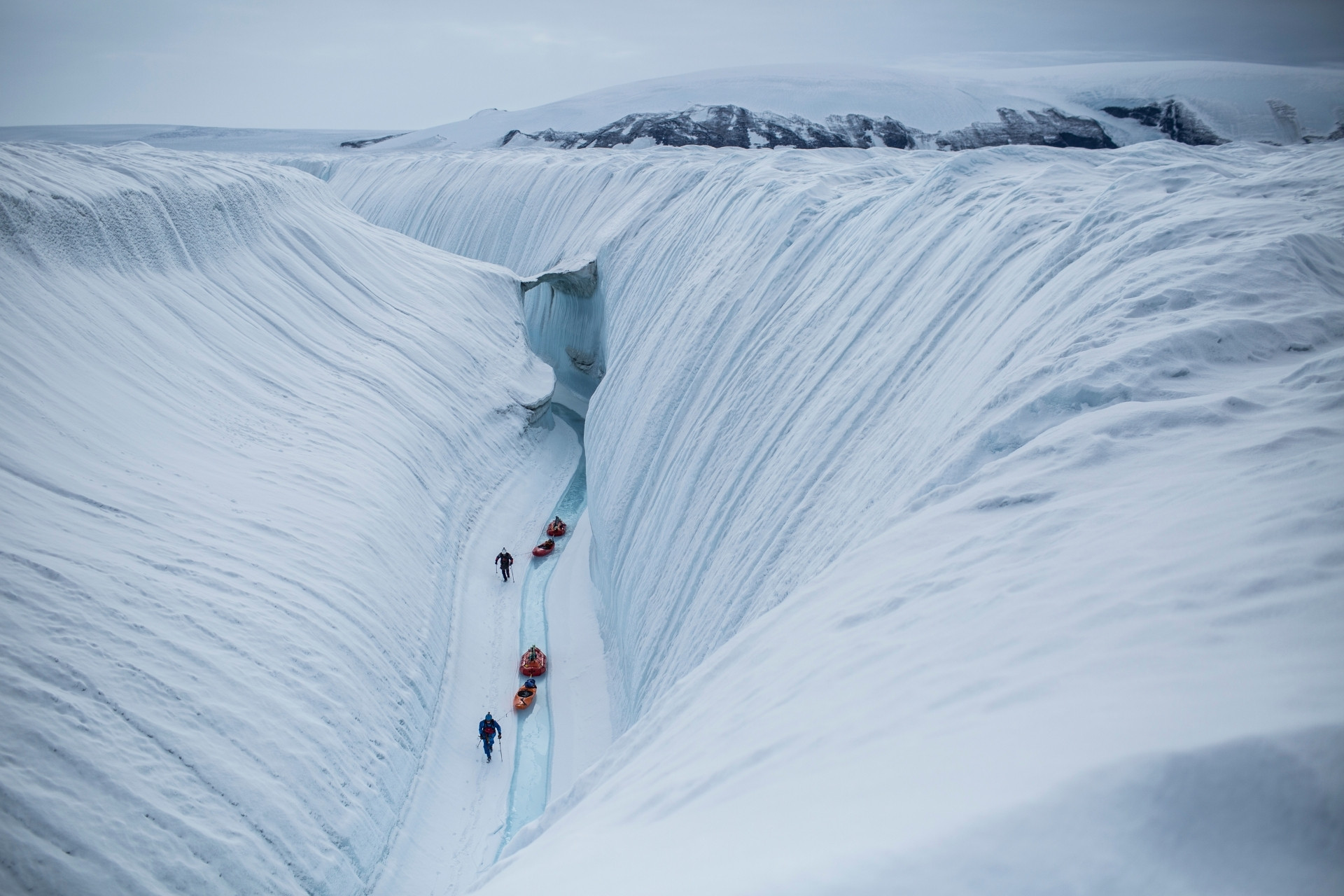 Menschen mit Schlitten in einem Gletscherspalte.