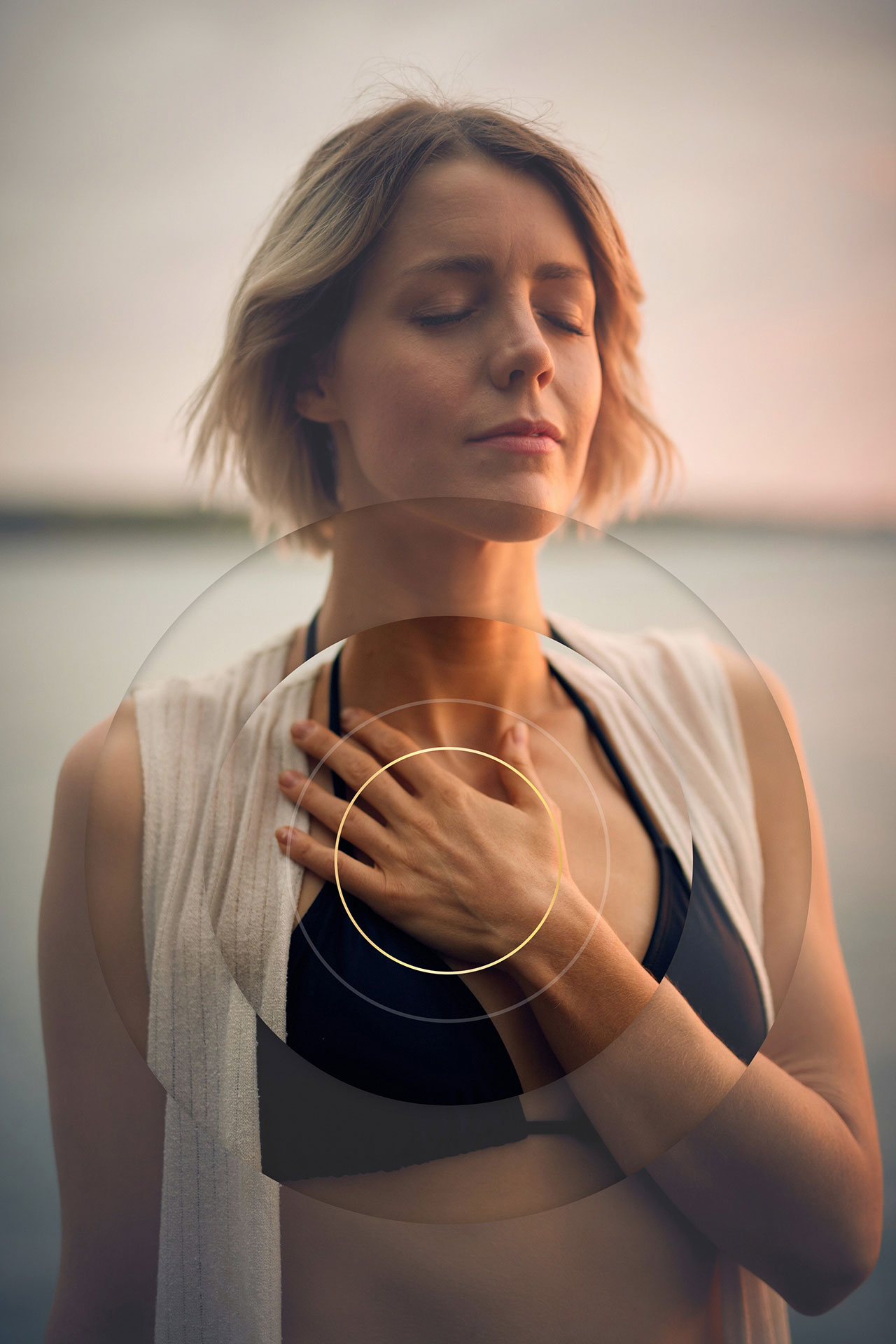 Frau meditiert am Wasser mit geschlossenen Augen.