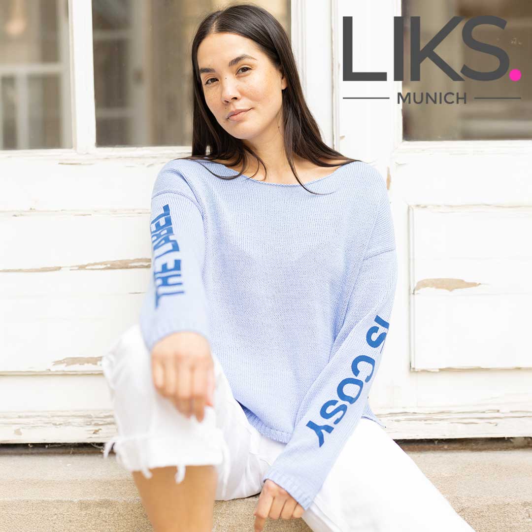 Frau in grauem Cardigan und pinkem Oberteil für Cosy Rosy.