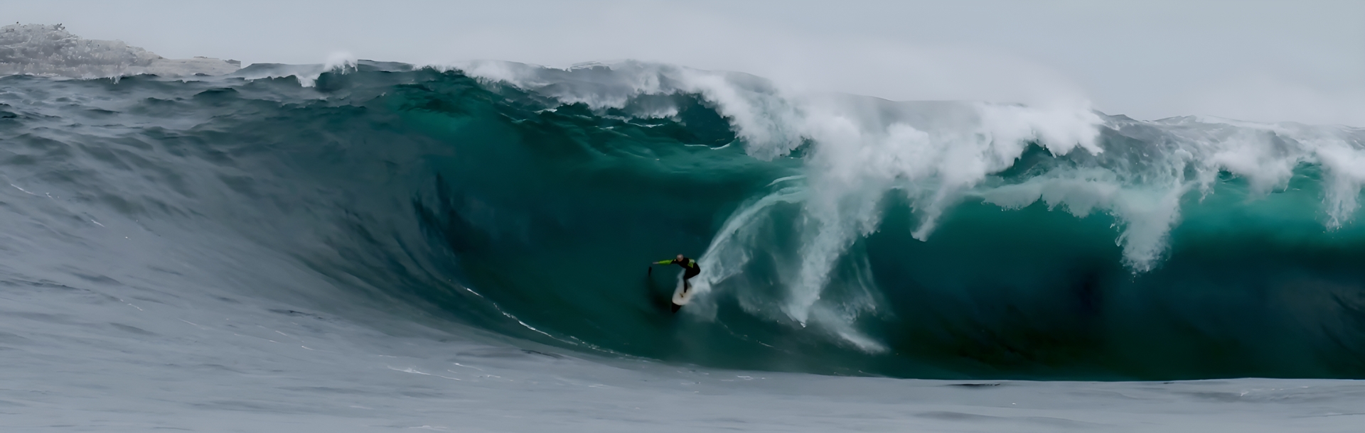 Surfer riding a large wave in the ocean.