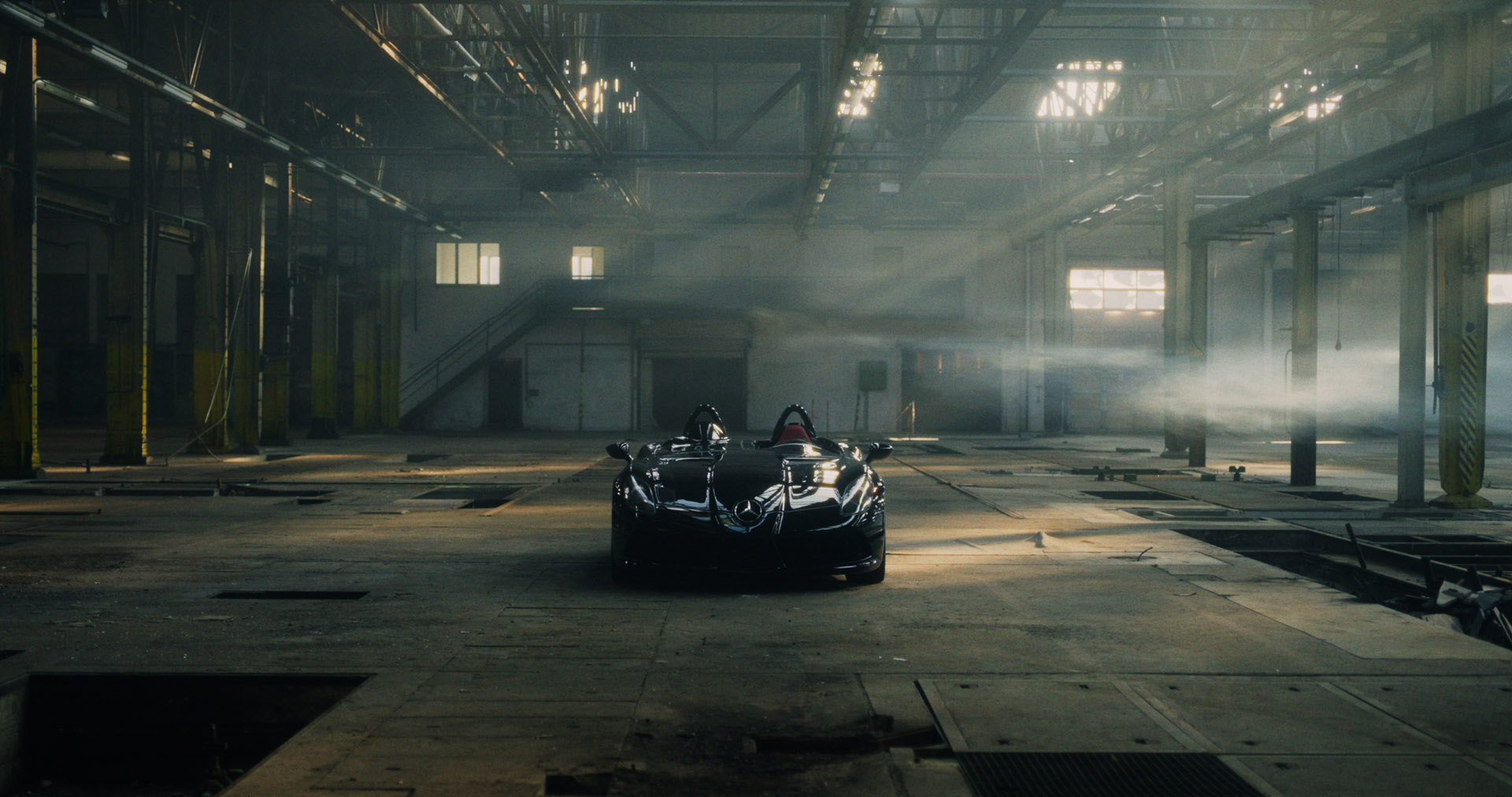 Schwarzes Hochleistungsauto in einer stillgelegten Halle.