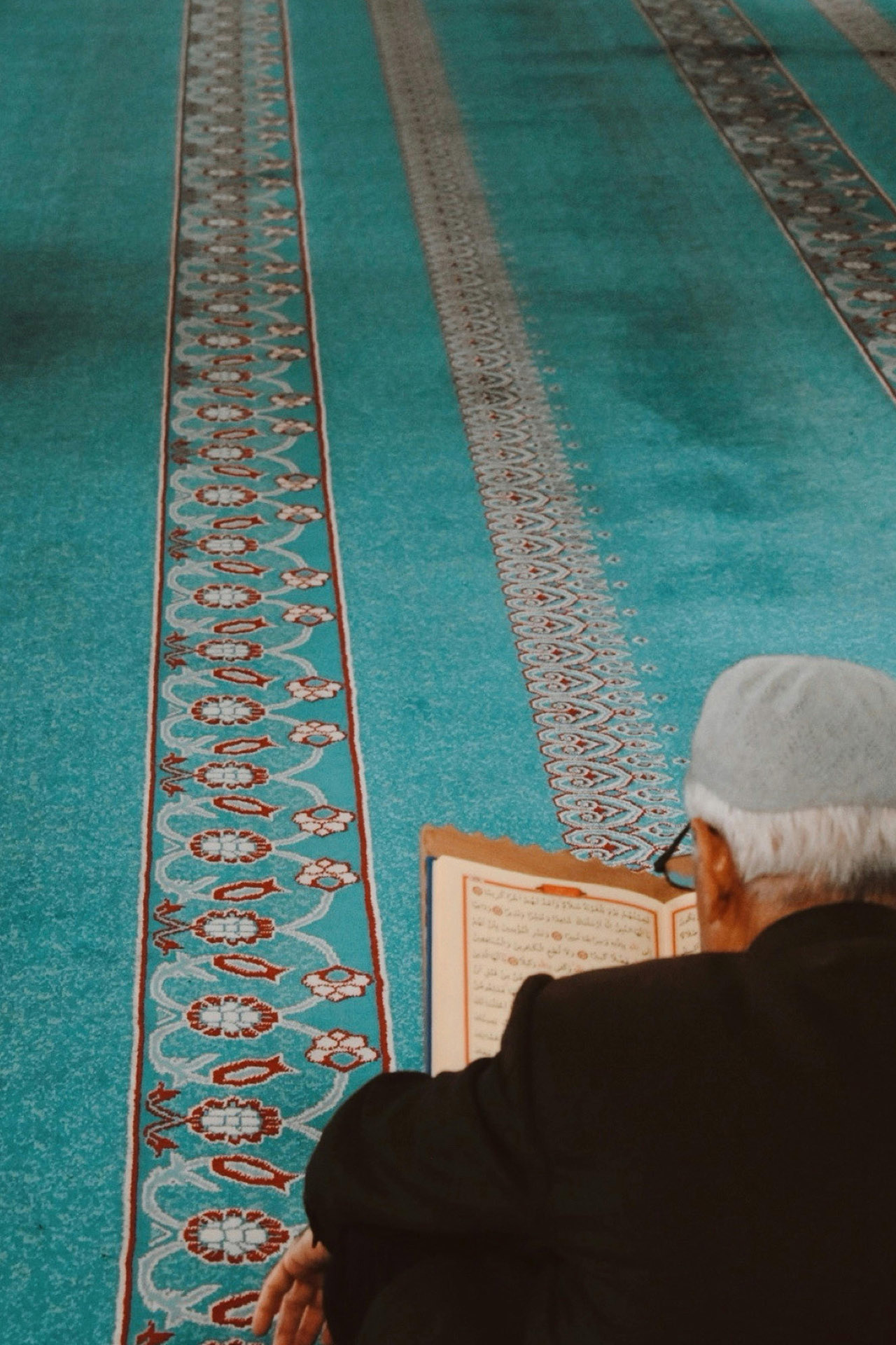 Älterer Mann liest im Gebetssaal