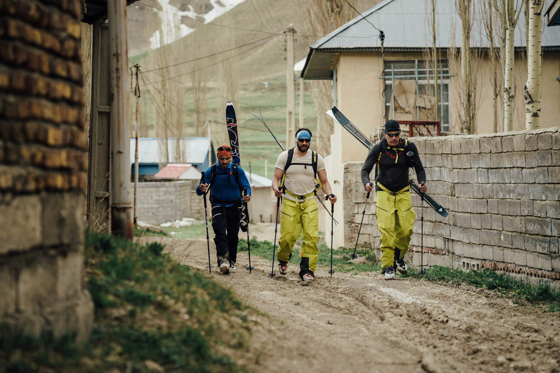 Drei Skifahrer gehen einen Weg entlang.