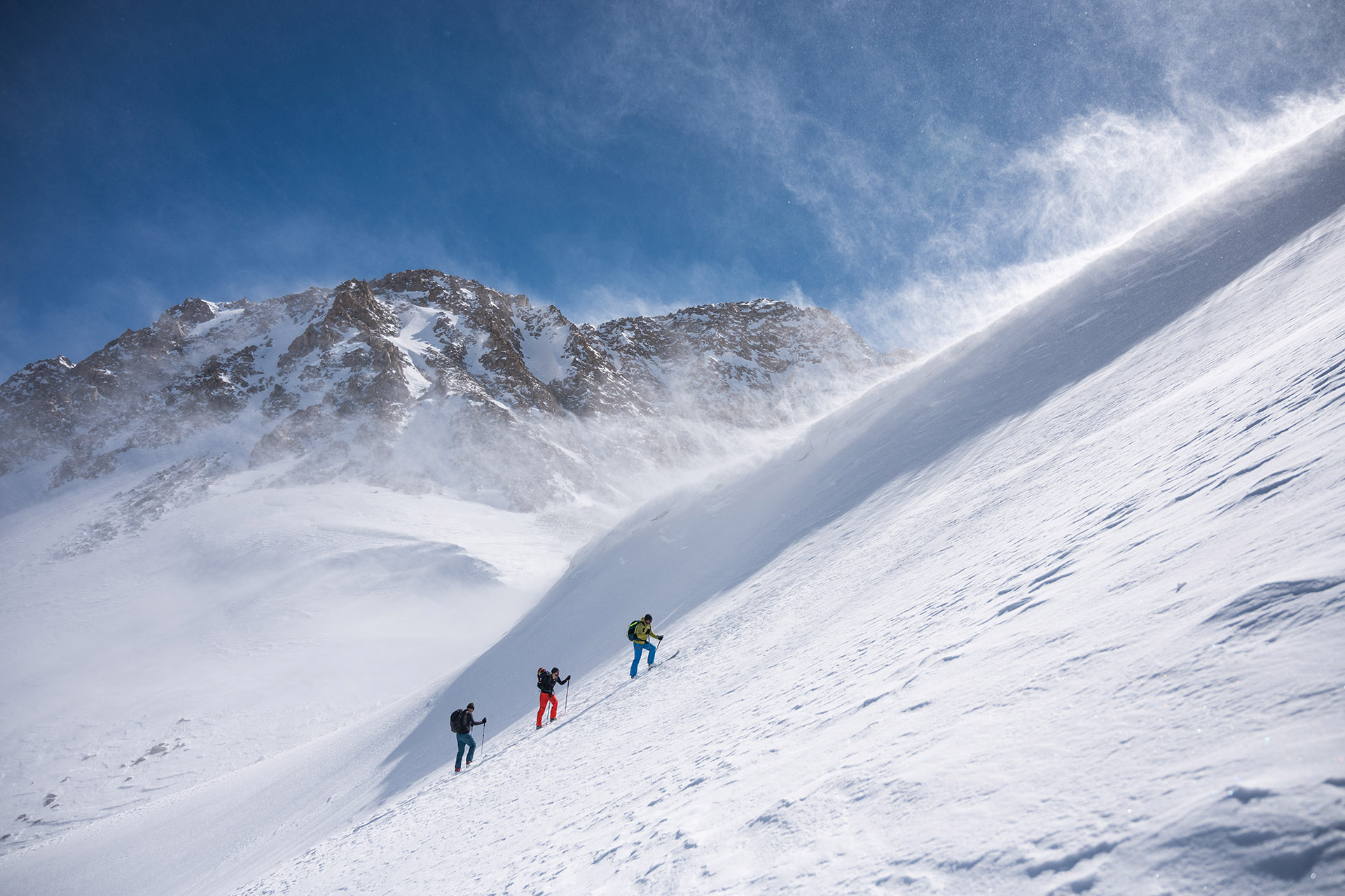 Drei Skifahrer im Schnee auf einem Berg.