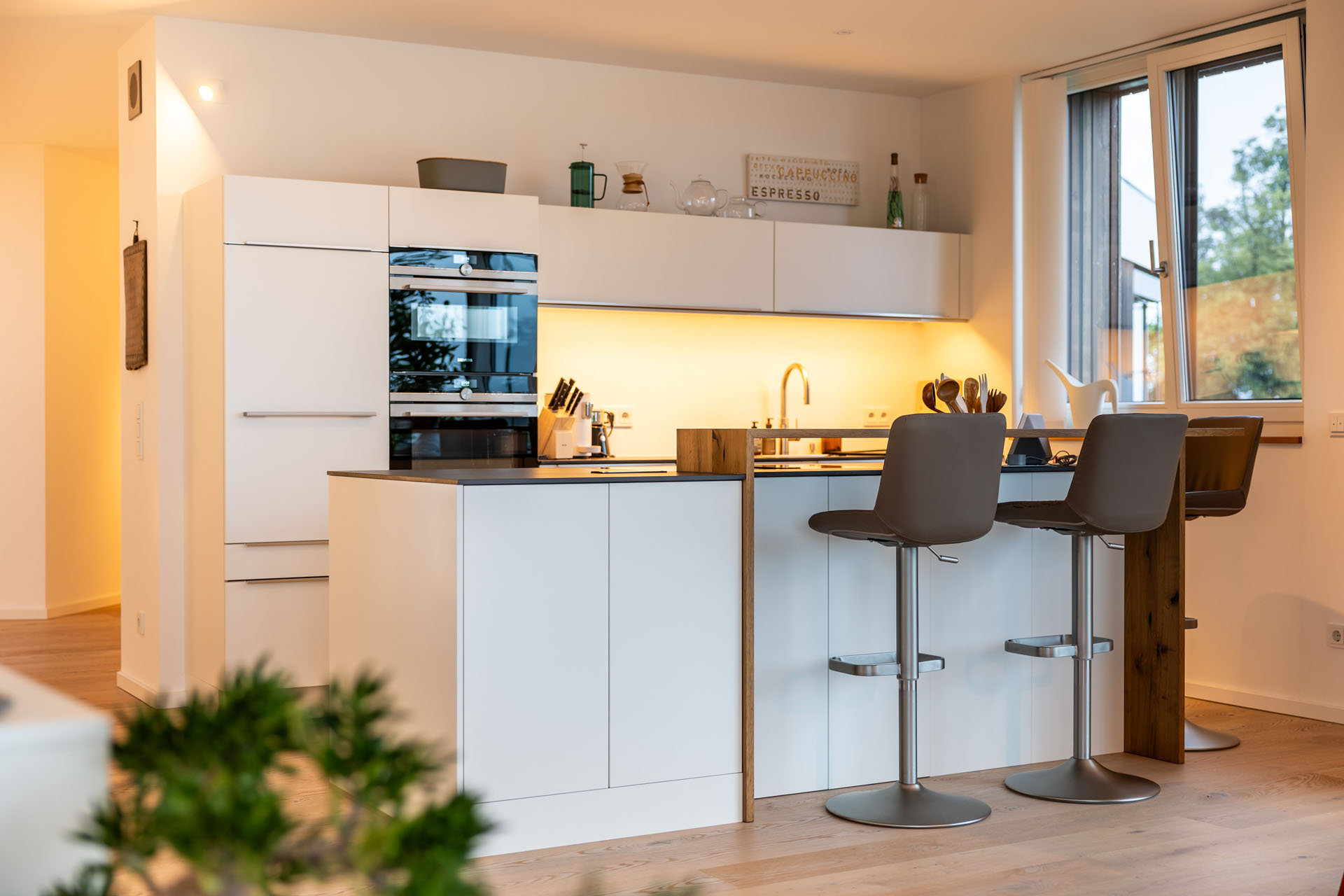 Moderne Küche mit Kochinsel und Barstühlen.