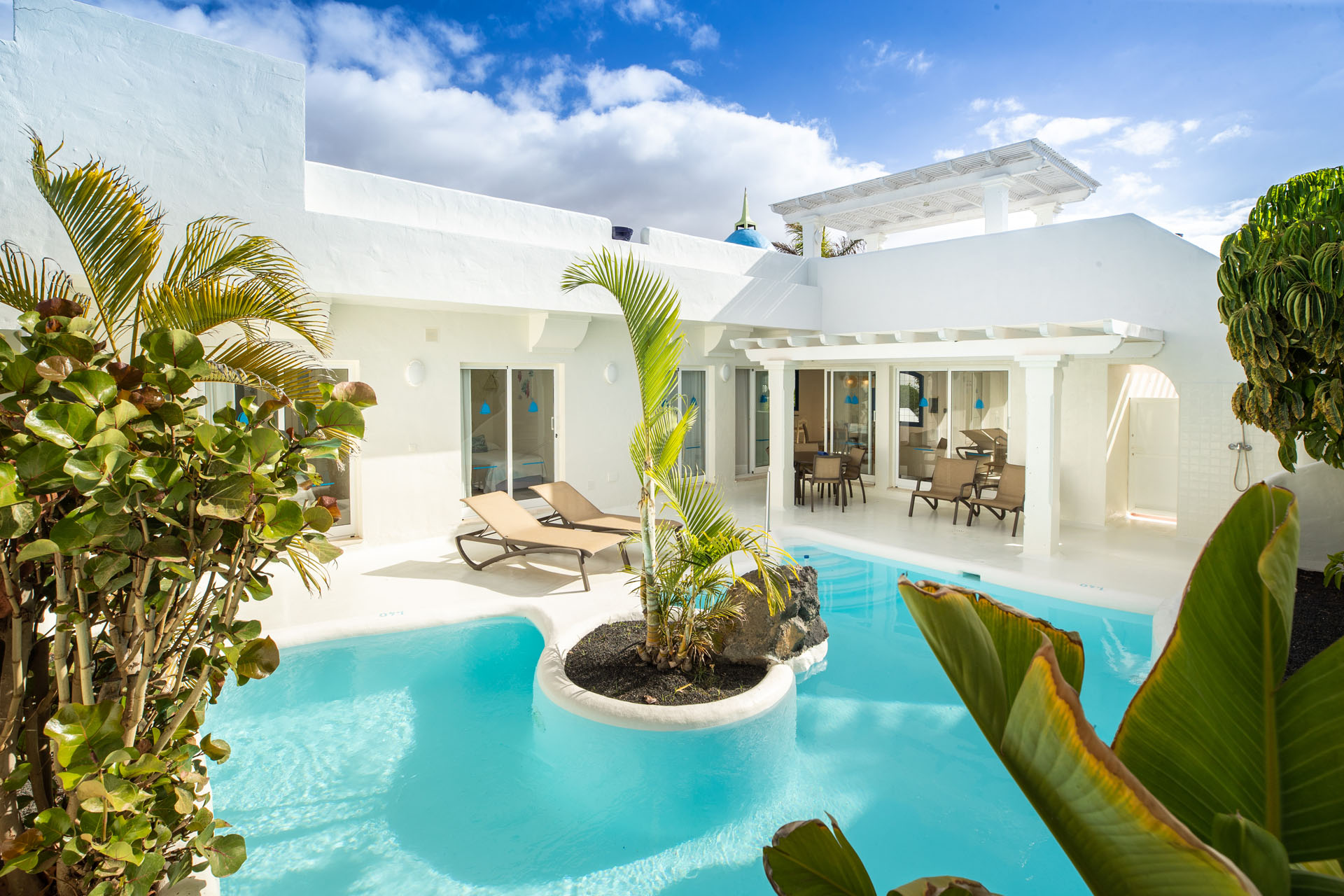 Moderne Villa mit Pool und Palmen.