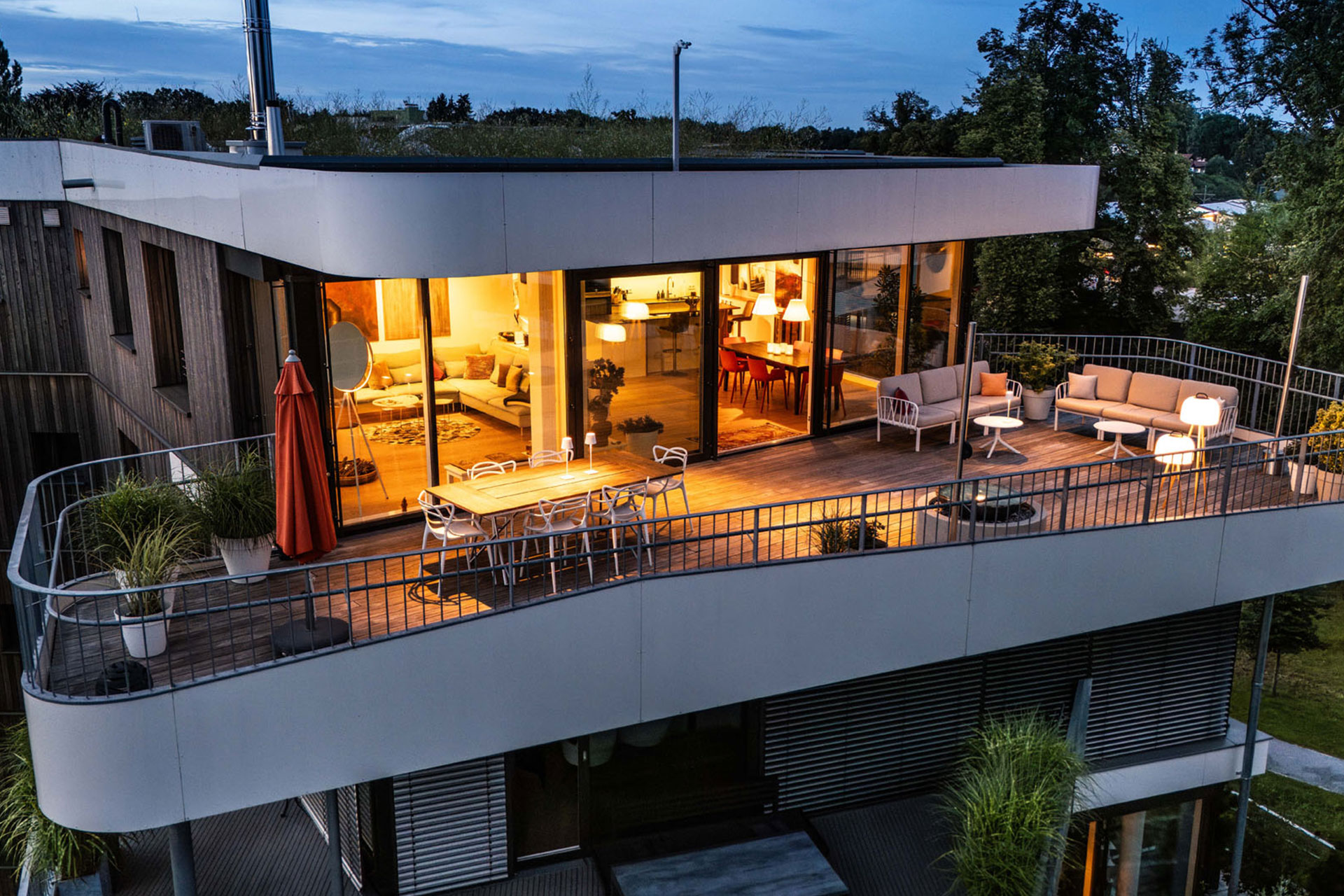 Moderne Wohnung mit Terrasse bei Nacht.
