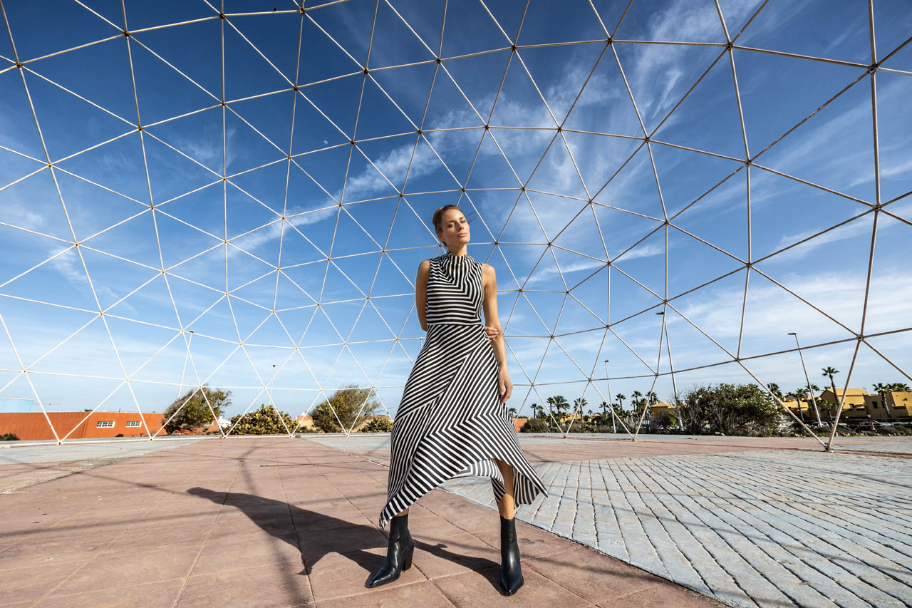 Frau in gestreiftem Kleid in Geometrie-Konstruktion