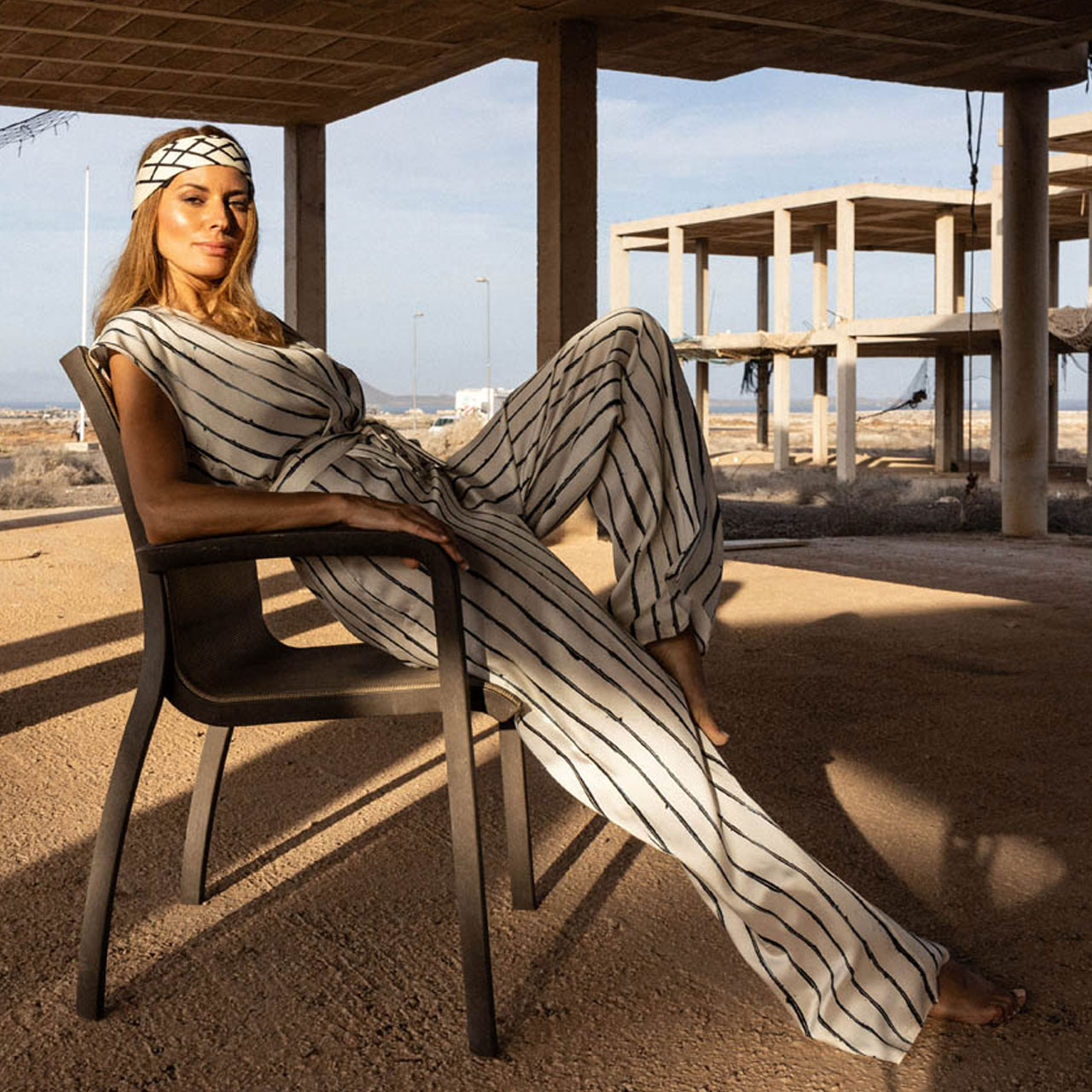 Frau mit gestreiftem Outfit auf einem Stuhl, Farmhouse7.